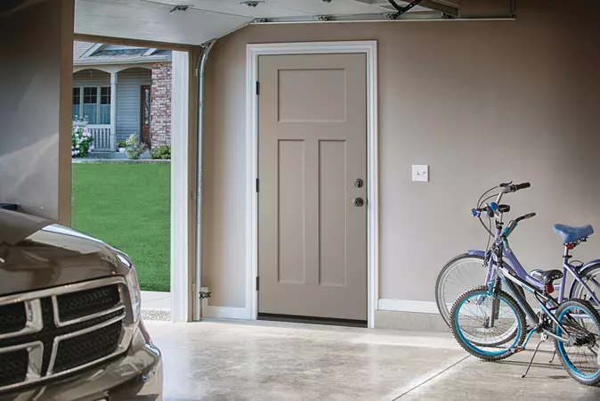 A Pavestone colored Smooth-Star Entry Door inside a 2-car garage