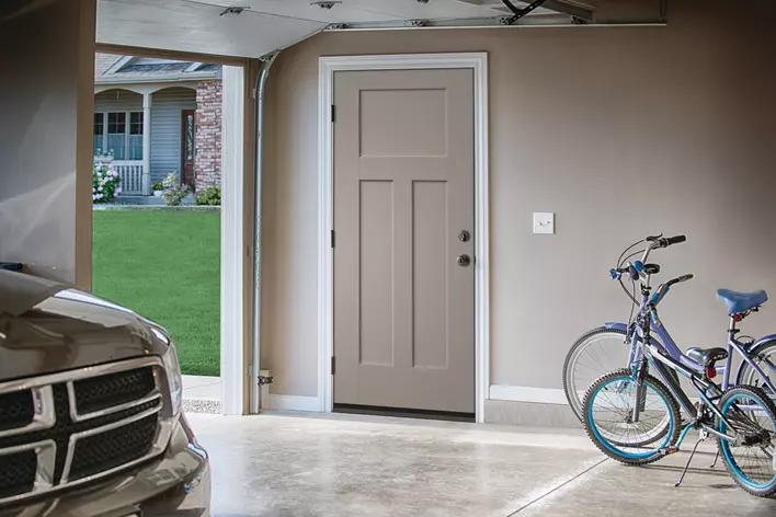 Interior shot of an open garage door with two bicycles and a vehicle inside the garage