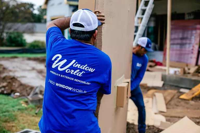 Window World workers carrying a garage door.