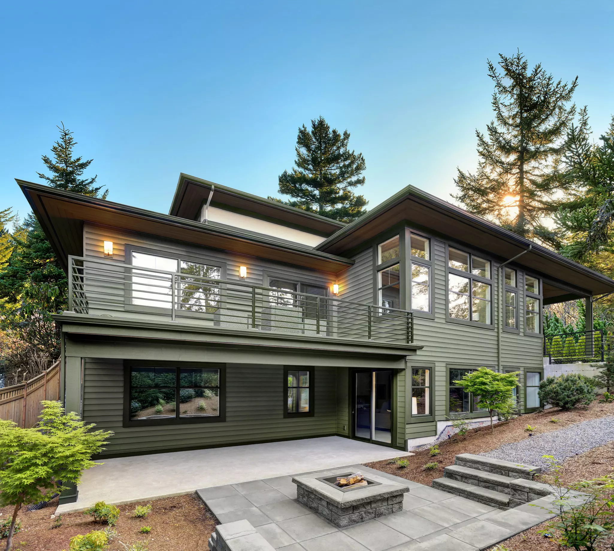 Exterior of a house with black trim windows and green paint