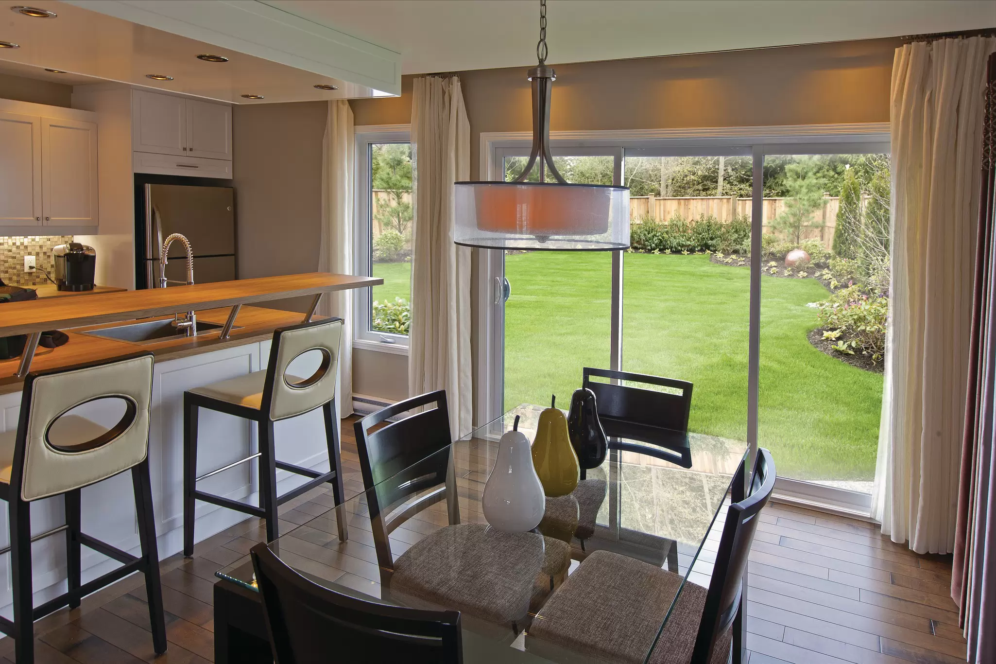 Sliding patio door off a kitchen dining area, opening to a fenced backyard lawn.
