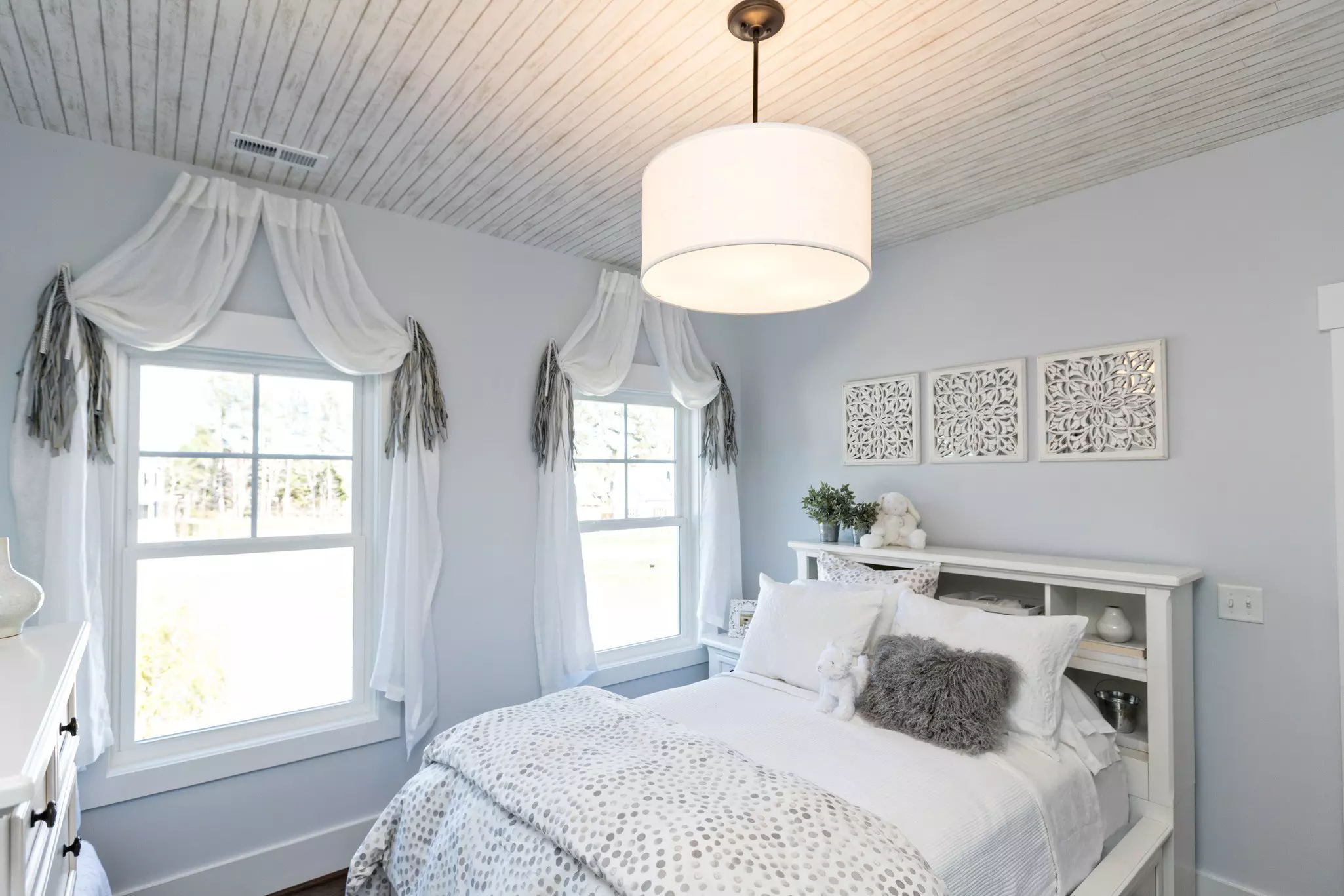 Bedroom with two double-hung windows and soft natural light.