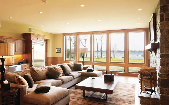 Quarter sawn red oak interior wood-clad awning windows in a living room with a lake in the background