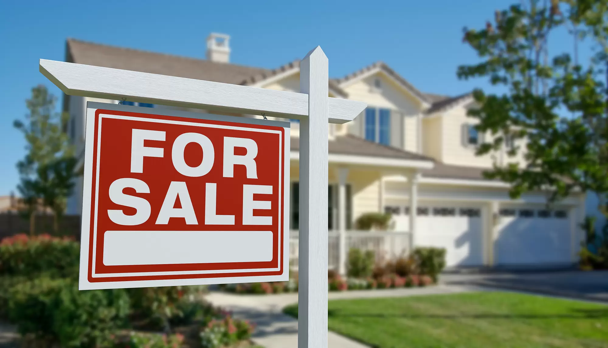 Red “For Sale” sign in front of a suburban home.