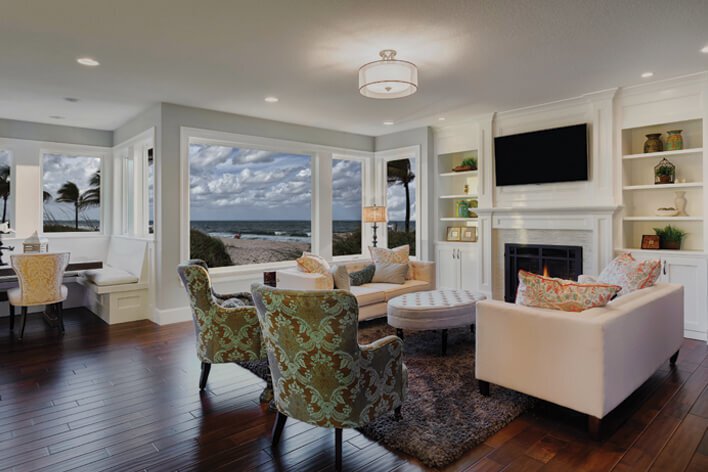 A living area in a beachfront home with large windows that a homeowner will need to prepare for hurricane season