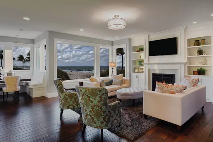 A living area in a beachfront home with large windows that a homeowner will need to prepare for hurricane season