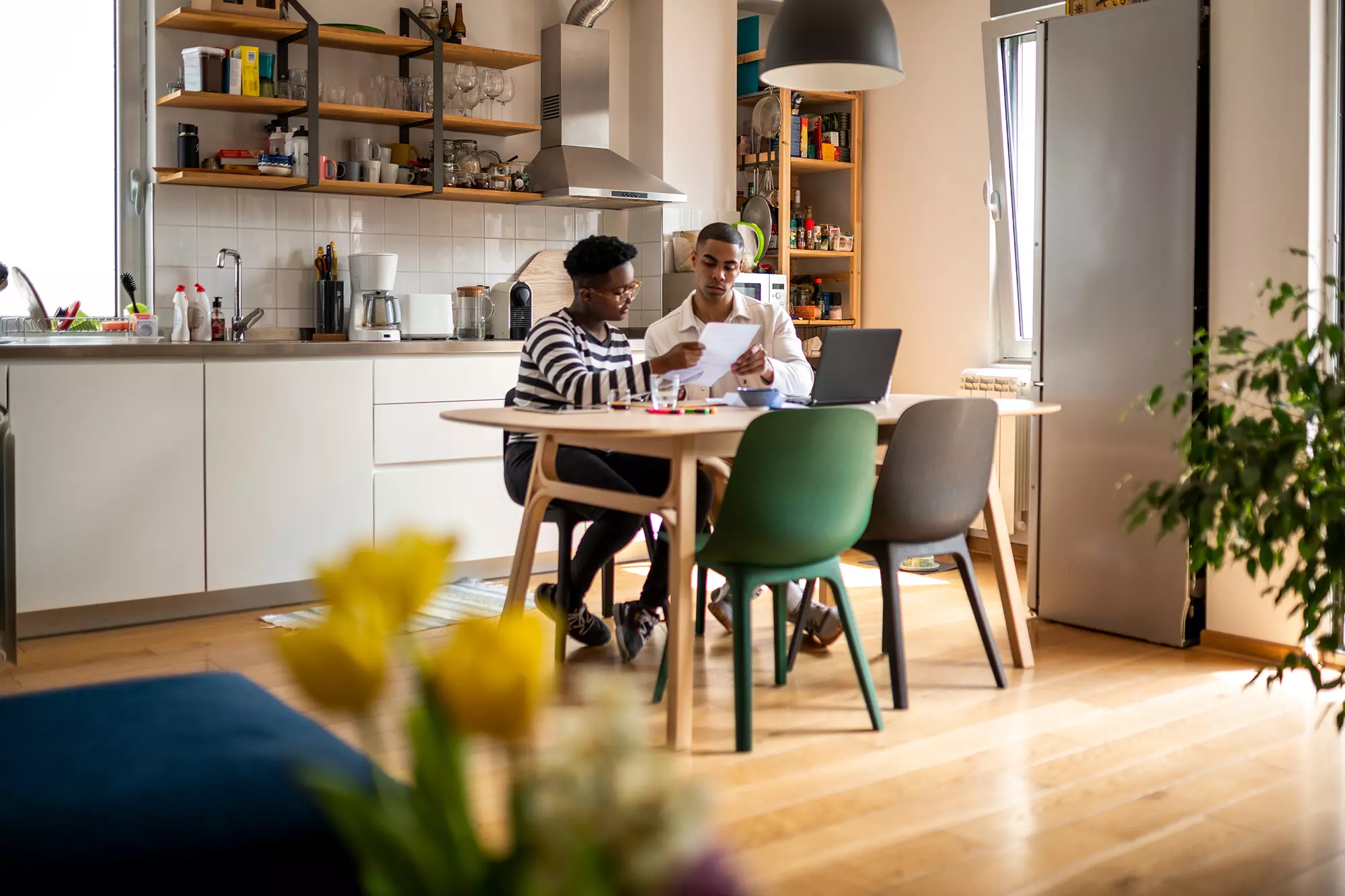 Couple reviewing documents at a kitchen table.