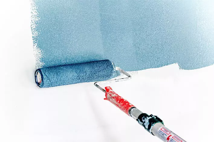 Paint being rolled onto a wall for a custom home project