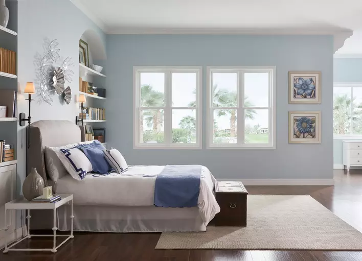 A bedroom including a bed and a rug with beach house windows 