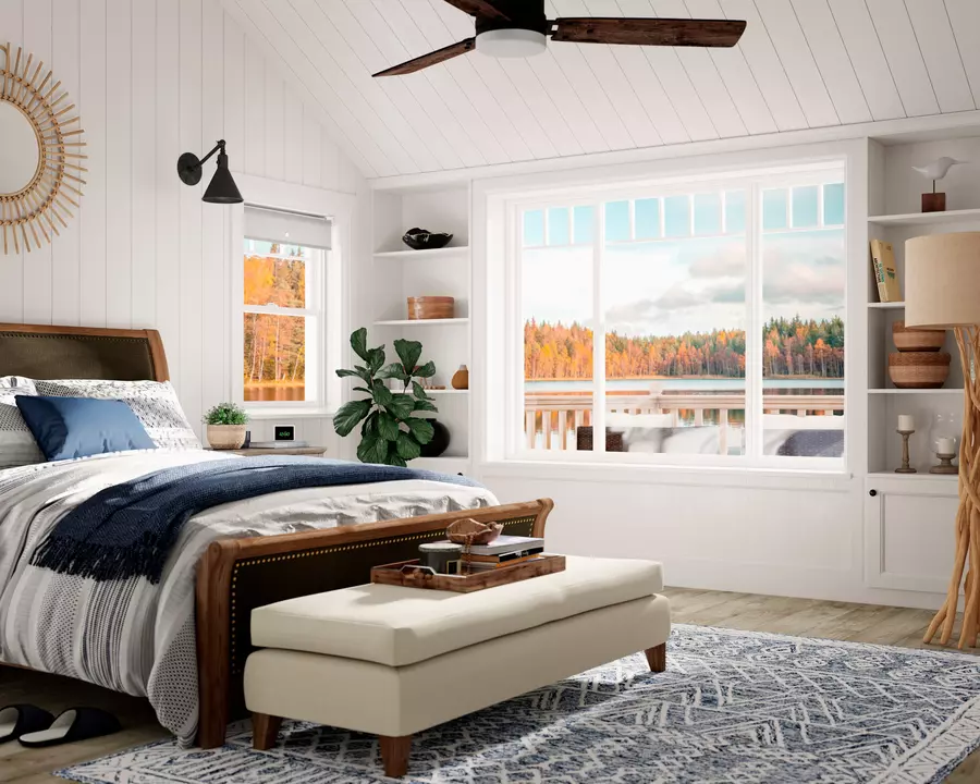 A bedroom with a large window and a view of the lake.