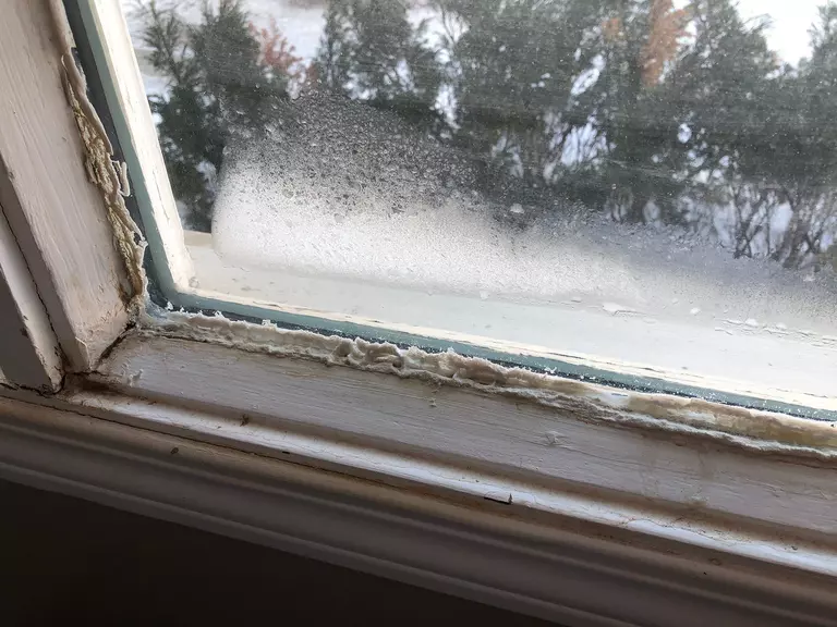 A window with old caulk around the edges of where the pane meets the frame.