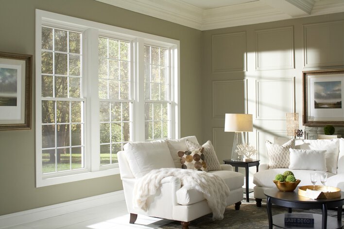 Living room with white couches in front of a window.