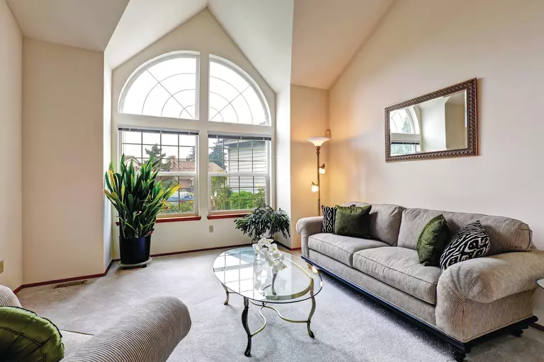 A living room exhibiting a custom arched window, a unique specialty window shape.