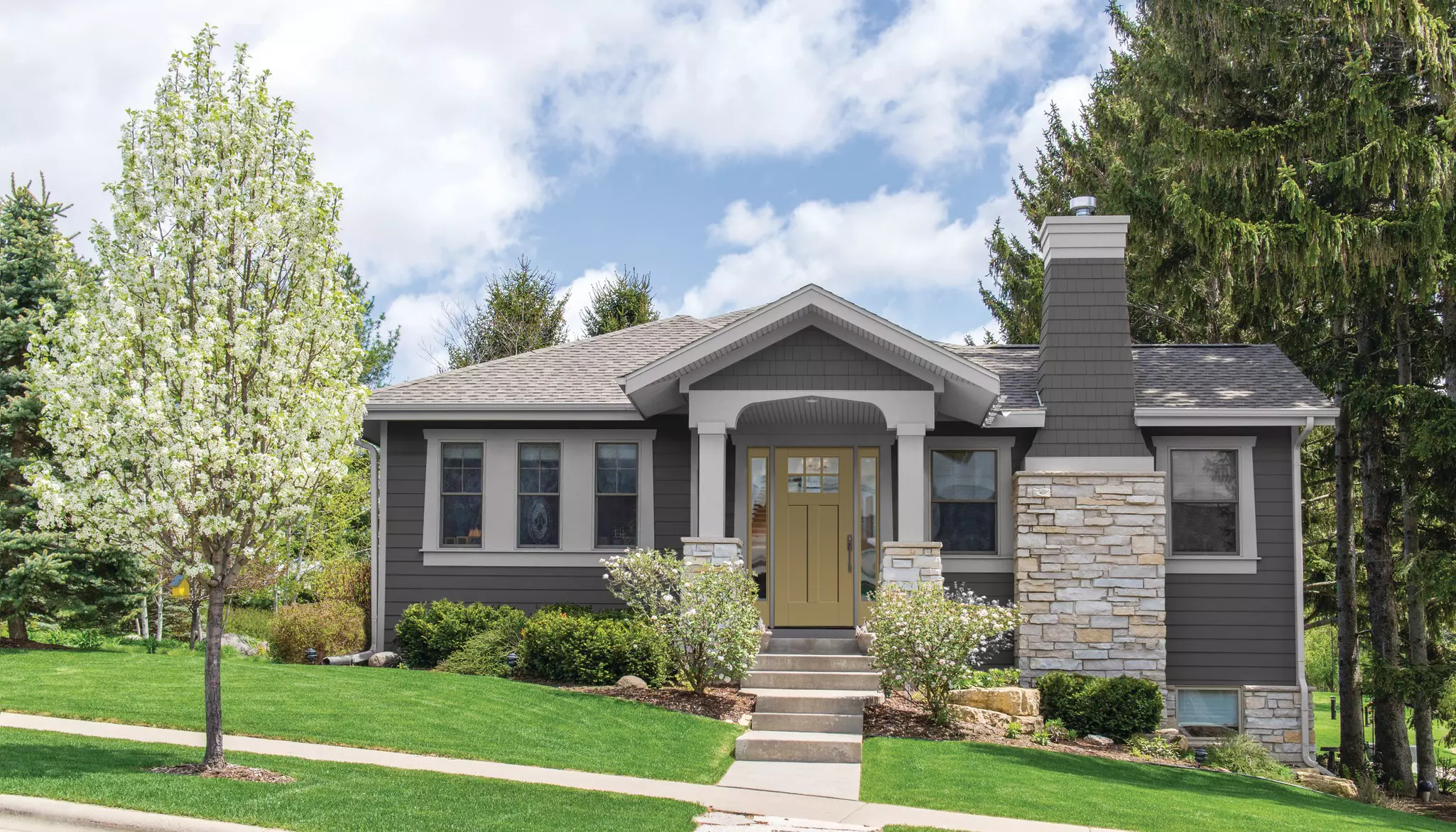 Small home with dark gray siding viewed from the street.