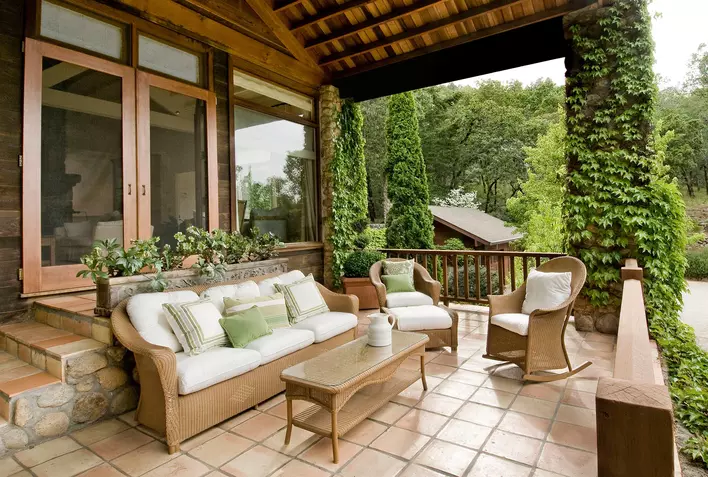The large front porch of an Asheville home that is decorated with pretty furniture and
shrubbery to increase curb appeal.