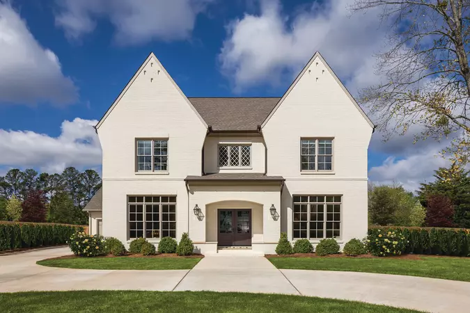A Black Bean colored Smooth-Star Entry Door on a opulent, white-brick 2-story home