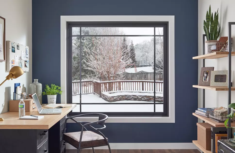 An office with a large picture window showing a snowy landscape outside