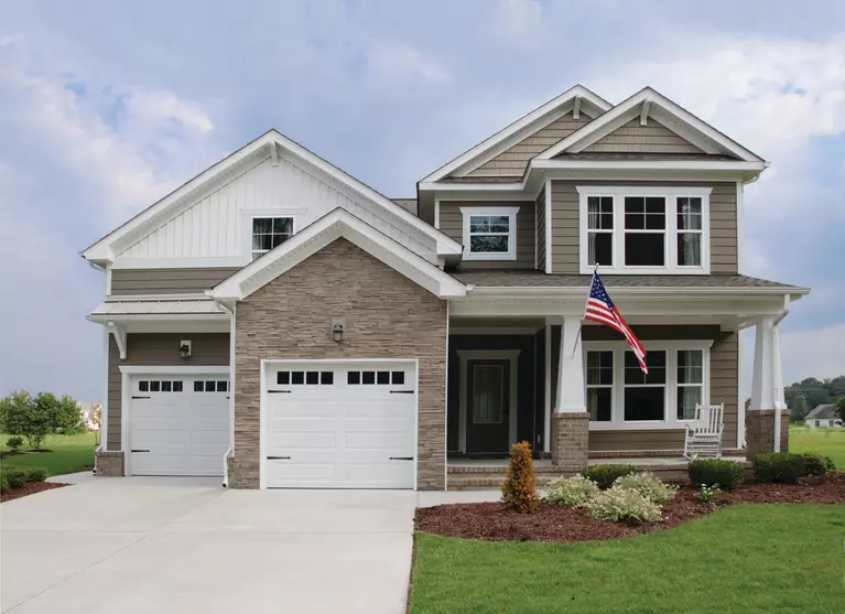 The front of a home with multiple window styles, plus vinyl siding and stone veneers.
