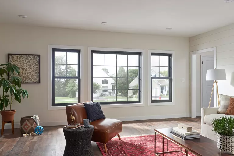 Interior of a living room with black square and rectangular windows.