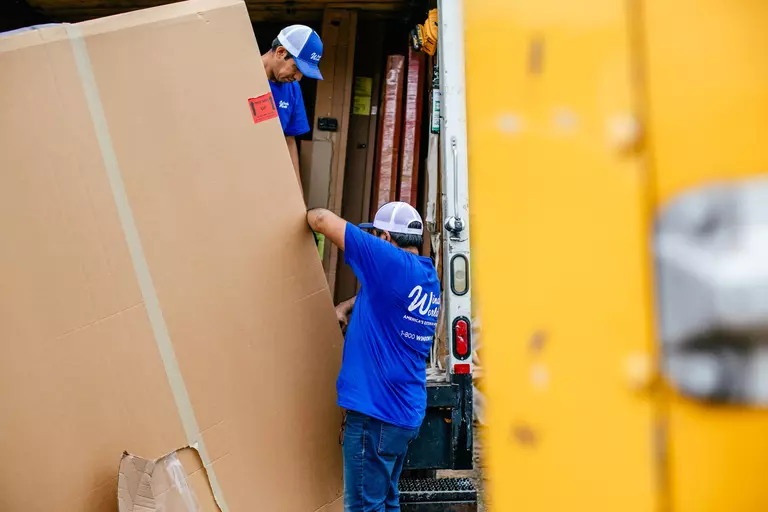 Window World crew hauling garage door replacement.