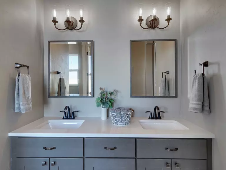 Bathroom vanity with two mirrors positioned above two sinks.