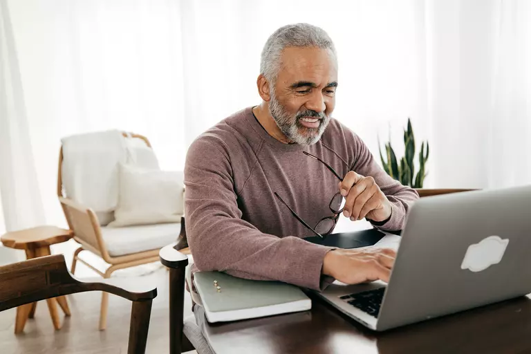 Man smiling while using a computer.