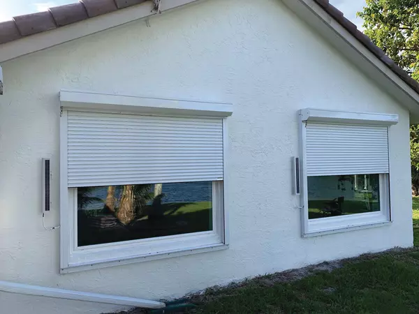 Solar powered, white Roll Shutters covering 2 windows