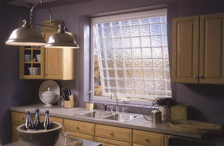 Kitchen with a large awning window opened slightly and featuring textured glass.