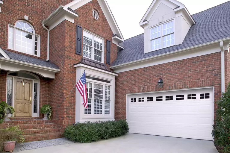 Home with a red brick exterior and a garage door with lites.