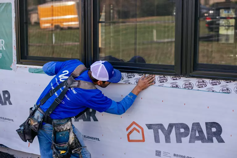Window World installation professional preparing the side of a home.