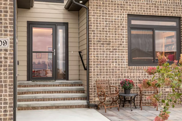  storm door with black trim in the entryway of a home, protecting against hazards like hail, debris strikes, and water damage.