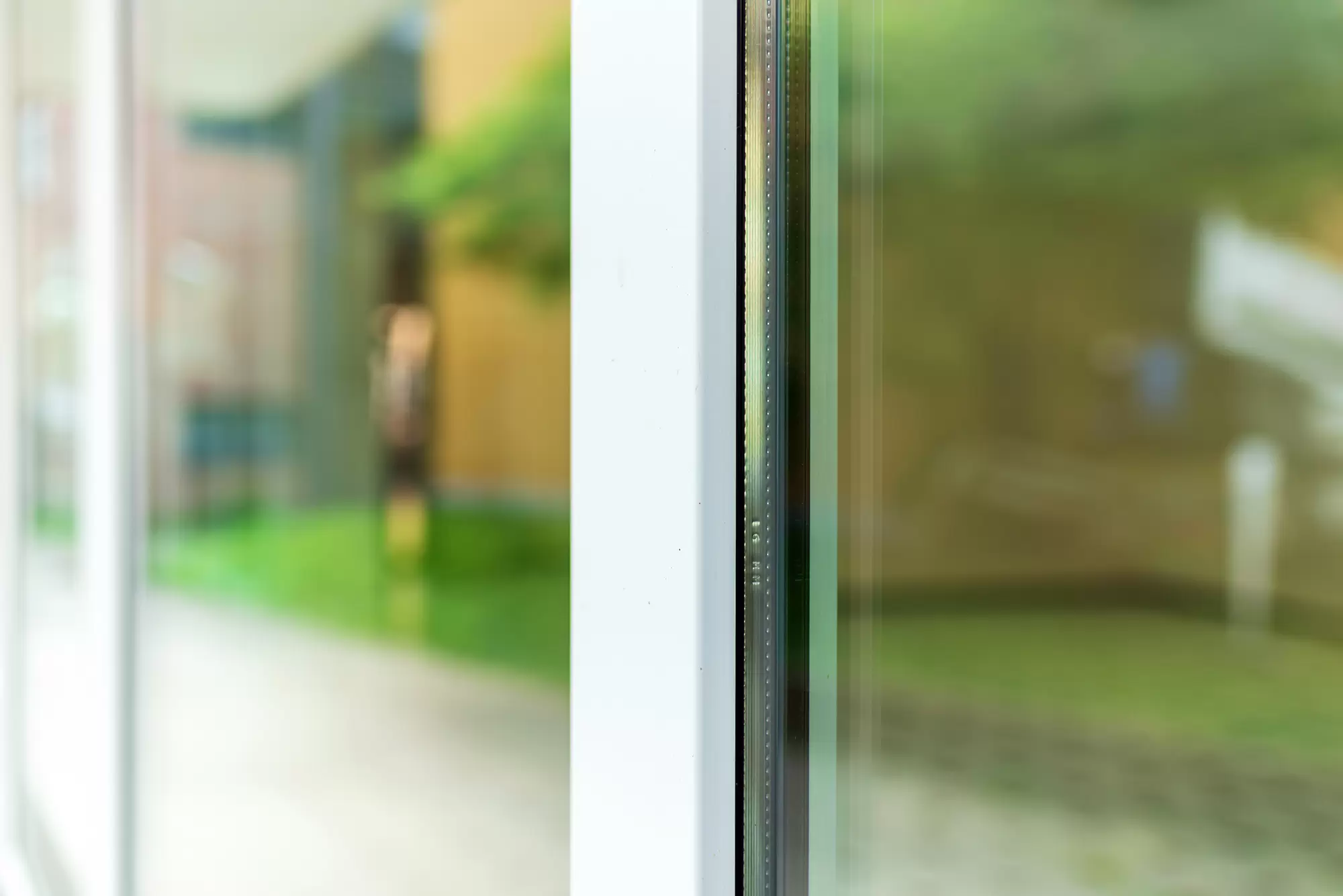 Modern glass window panels reflecting trees outside.