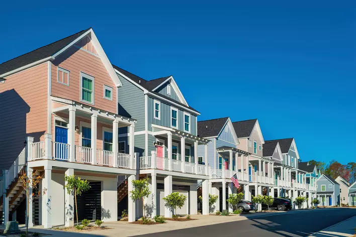 A row of colorful beach houses, including one painted the 2024 Color of the Year
