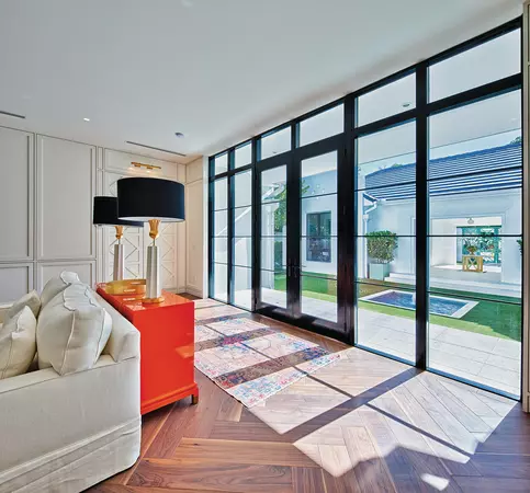 A black hinged patio door with 2 functioning panels in a living room.