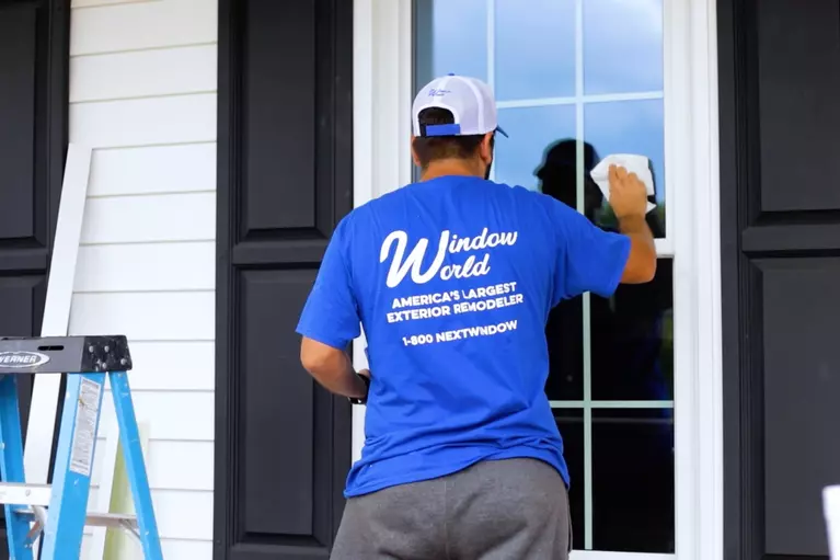 A Window World employee cleaning a newly installed window.