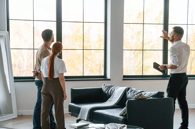 A man showing windows to a couple.