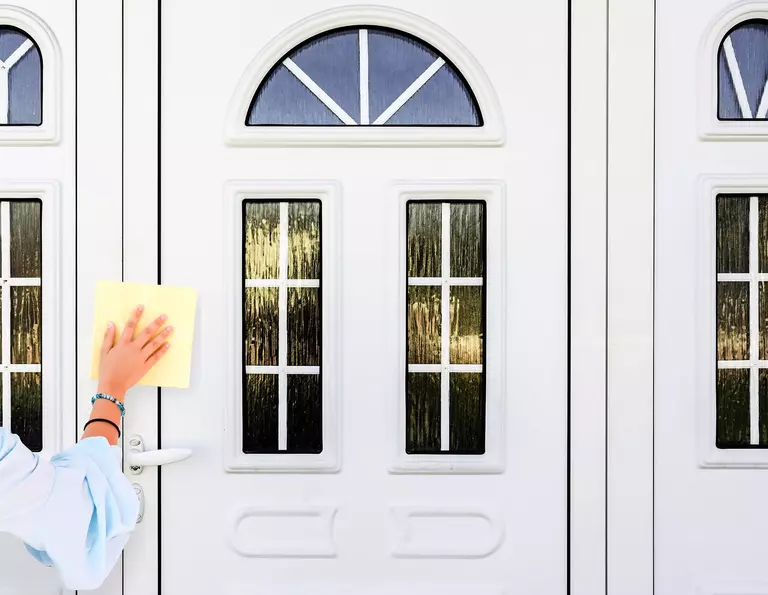 Person using a cloth to clean the edges of a door.