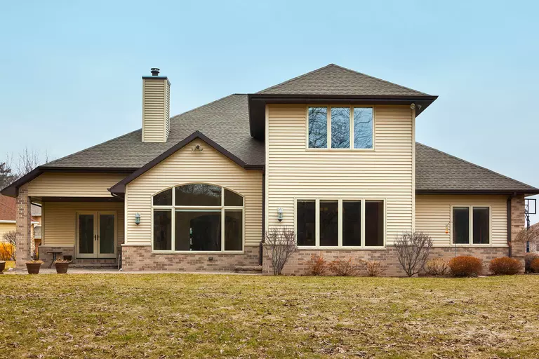 Exterior of a home with beige window frames and siding.