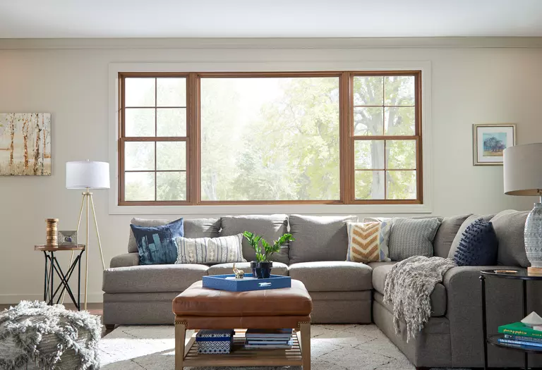 Interior of a living room with a large picture window and double-hung windows featuring grids