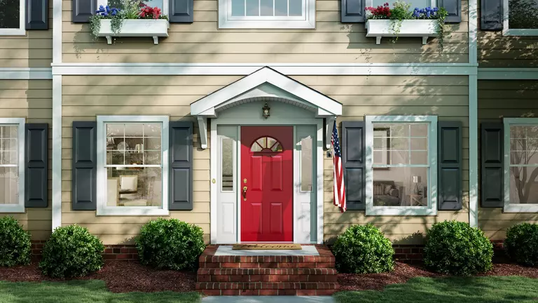 Home with 1000 Series siding from Window World with a red entry door and windows that have gray exterior window shutters.