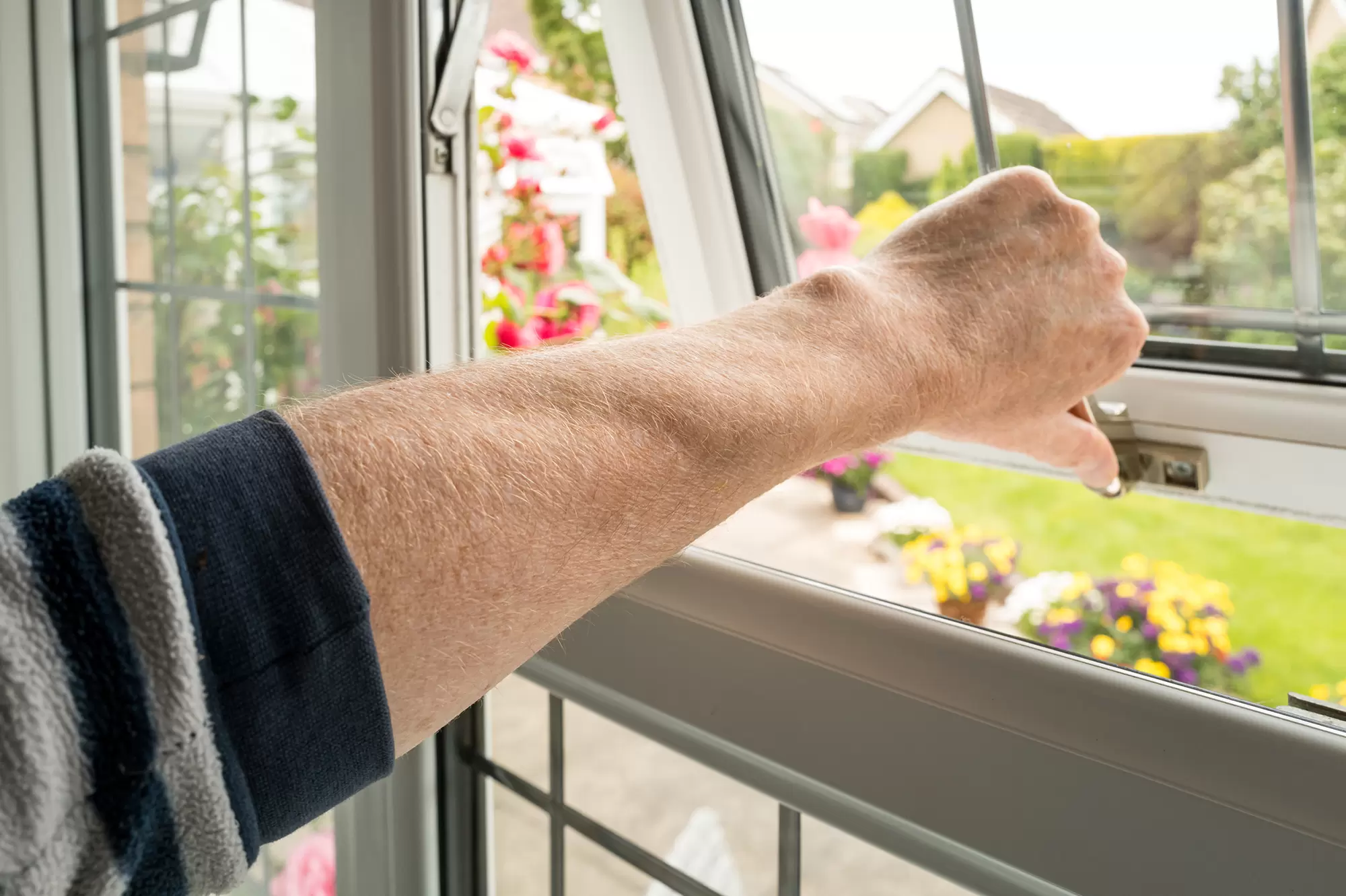 Close-up of a person opening an awning window.