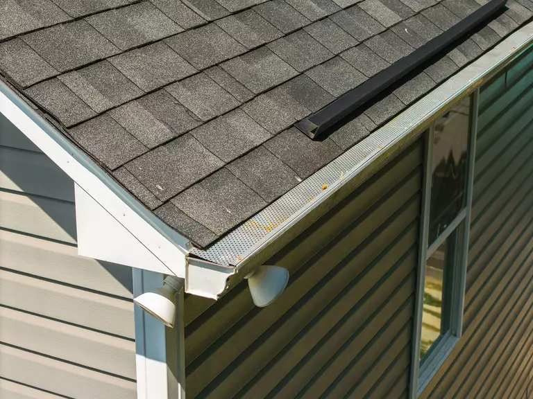 View of home with gutter system shown from the roof and a light attached.