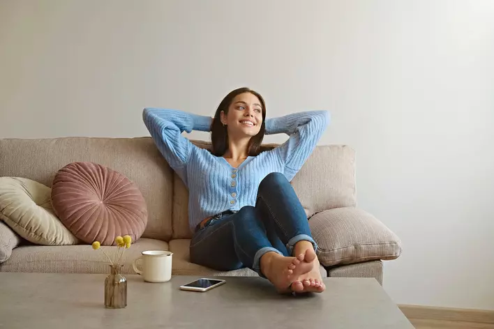 Woman smiling while sitting on a couch in a house