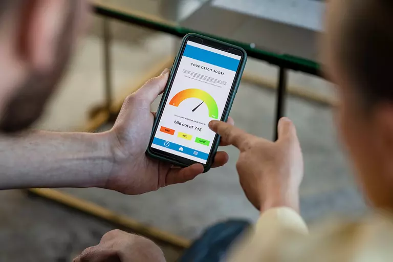 Couple reviewing a credit score graphic on a smartphone.