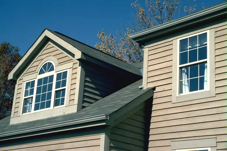 Exterior of a home with unique specialty window shapes.