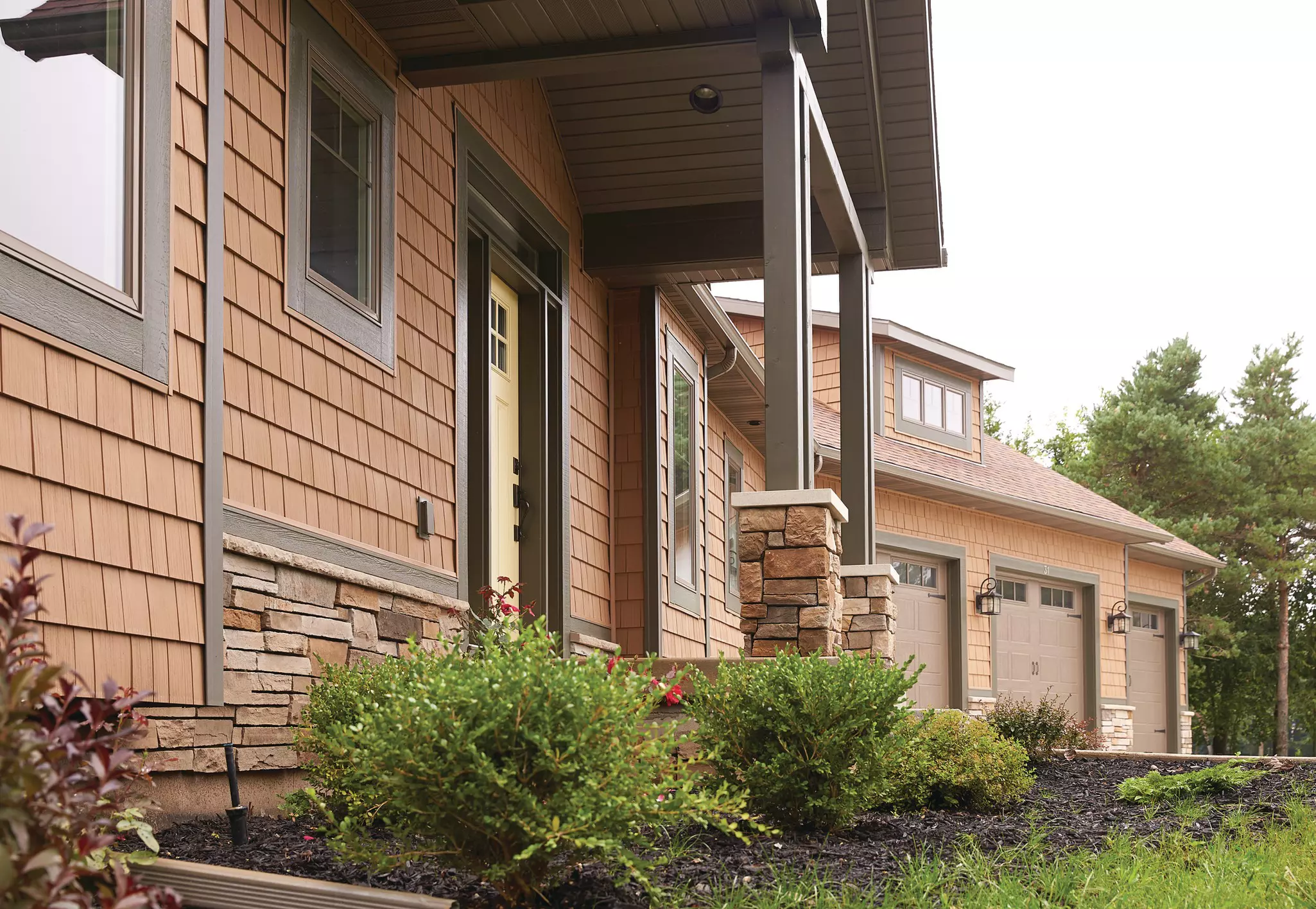 Side view of a home with brown colored mastic siding.