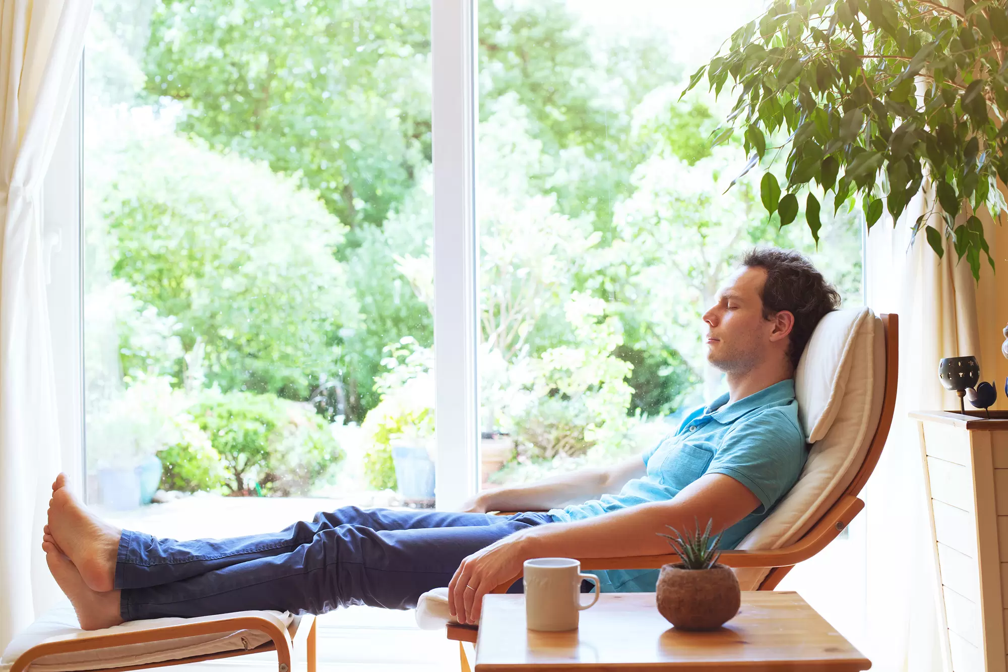 Fatigued man sitting indoors on a lounge chair.