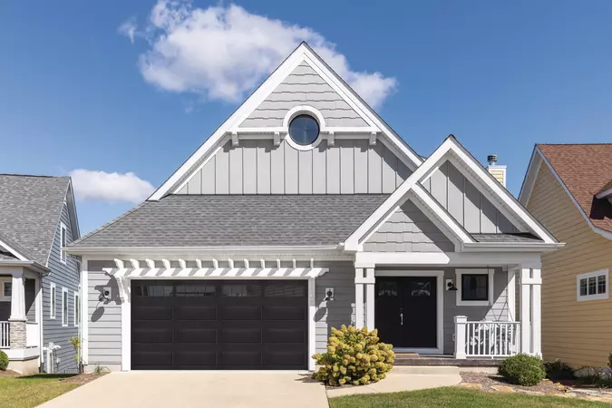 Black residential steel garage door with Stockton windows