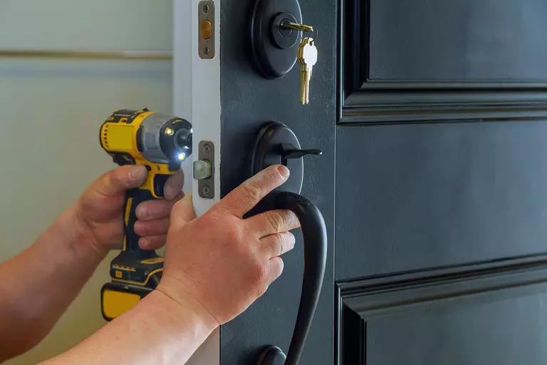 Person adding locks onto the doors of their home to increase security.