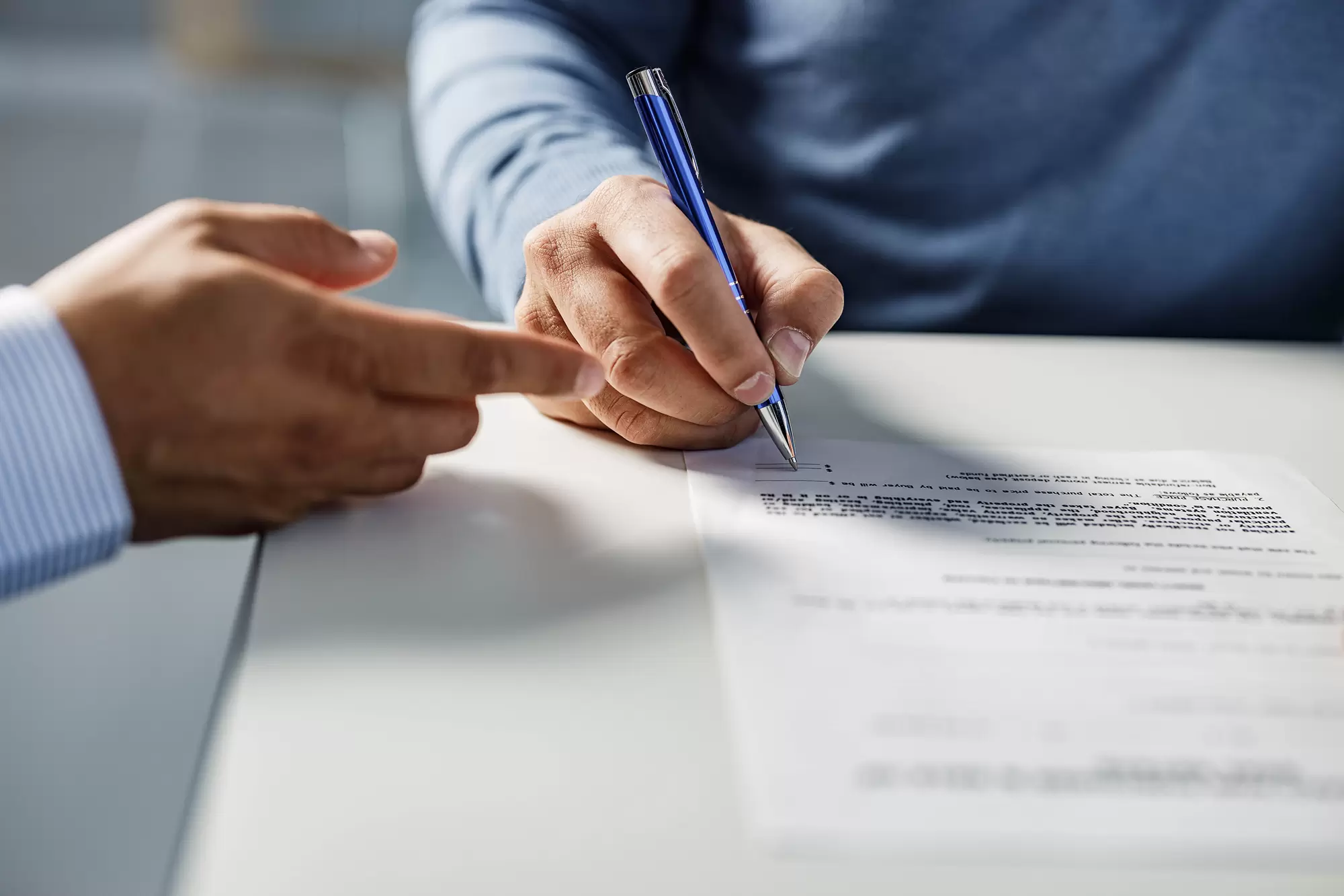 Close-up of a document being signed with a pen.